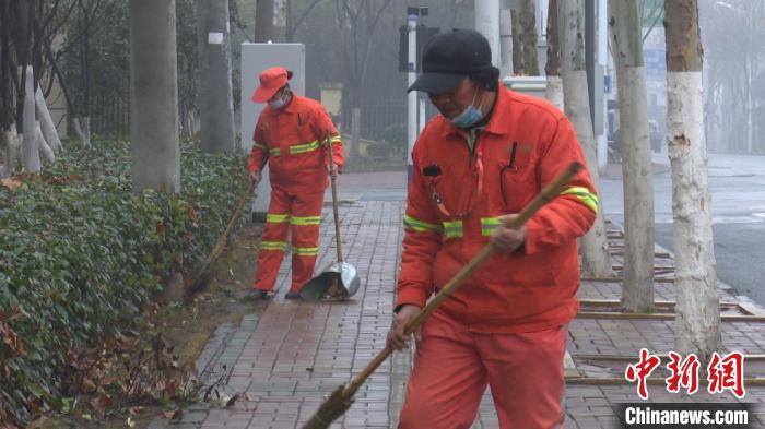 1月23日,65岁的程松林正在清扫马路上的落叶.