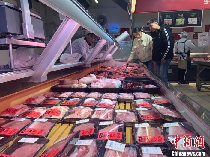 资料图：长沙市民在超市选购猪肉。 