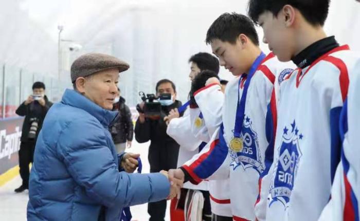 北京市体育基金会理事长孙康林和选手握手。图片来源：北京市体育局。