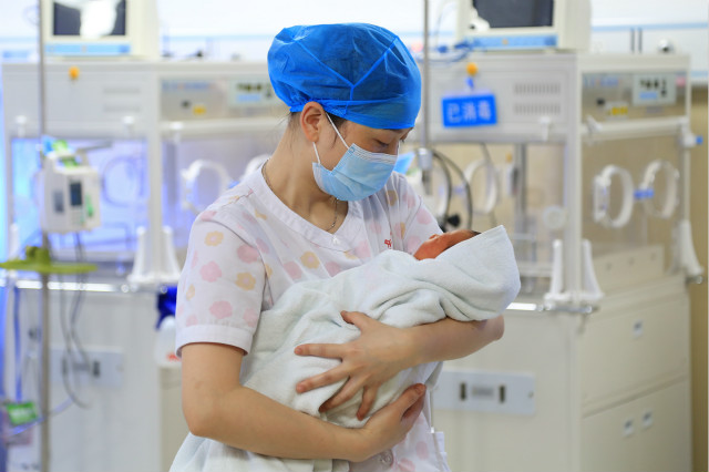 2020年5月11日，贵州省余庆县人民医院新生儿科护士长冉晴在护理新生儿。新华社图。