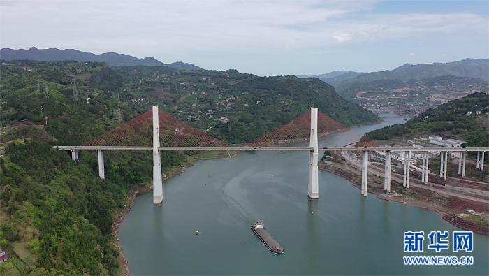 4月8日，G42沪蓉高速上一桥飞架两岸，货轮行驶在江面上。新华网 